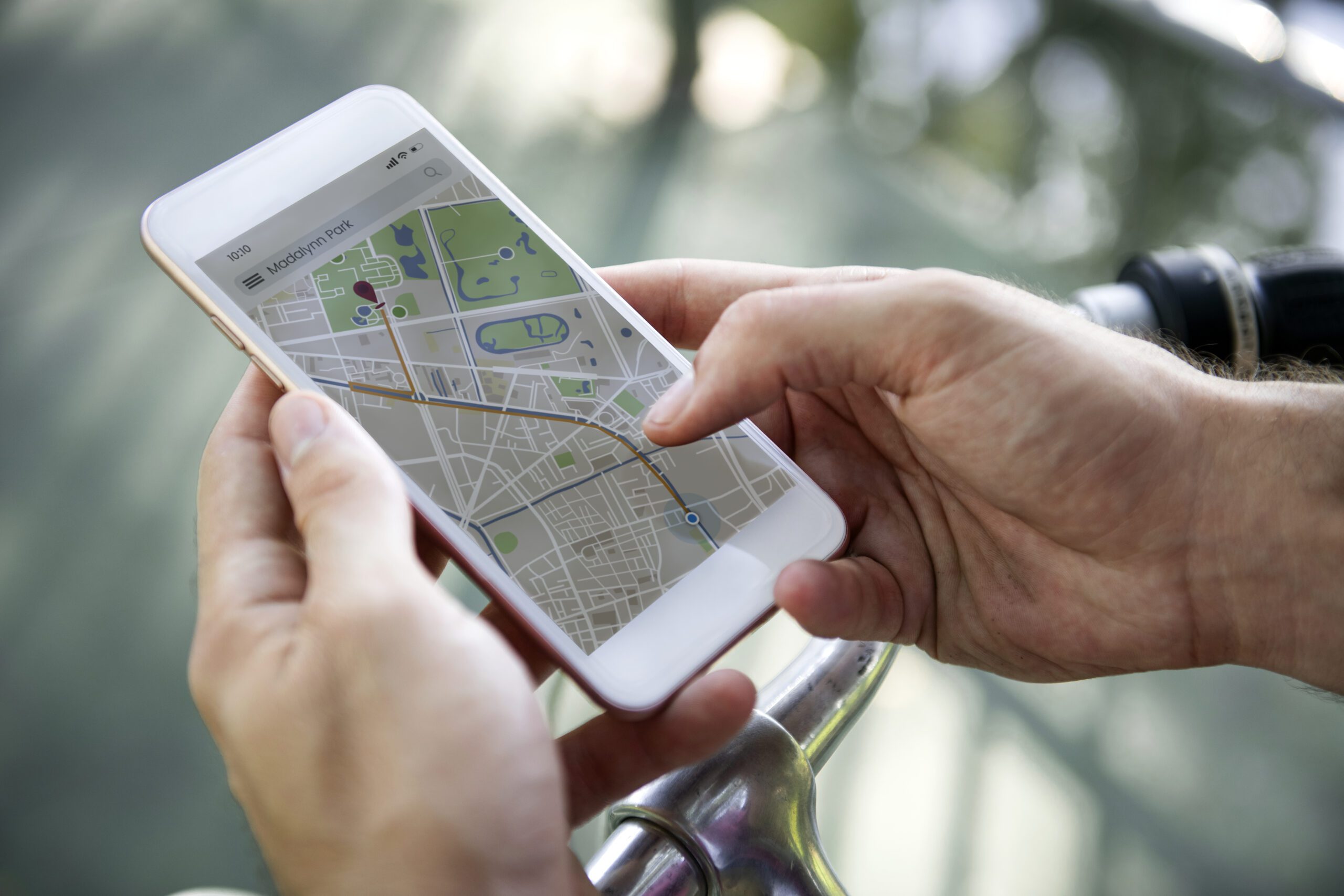 Hands holding a smartphone displaying a GPS navigation map.